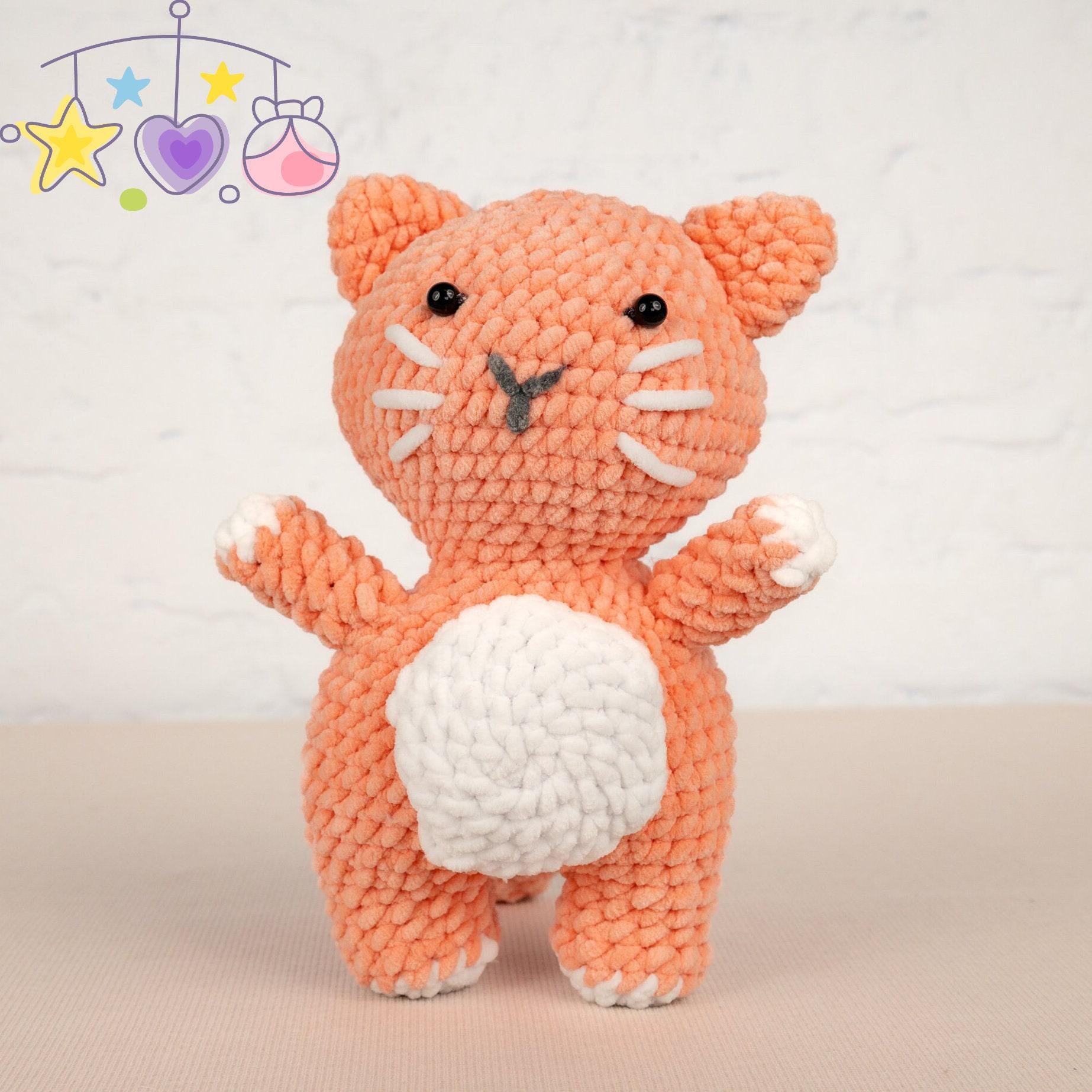 a crocheted cat sitting next to a ball of yarn